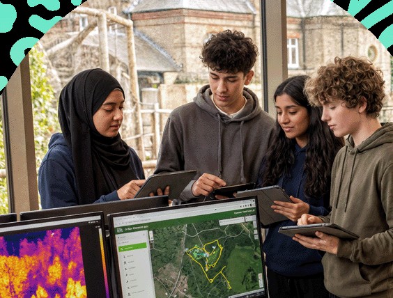 Four students working together on tablets and laptops