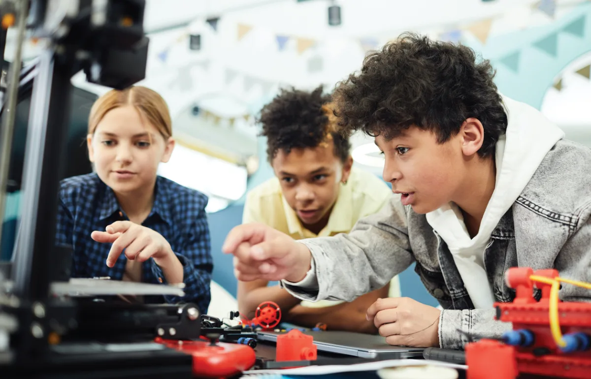 Three young people building a robotics project at a Digital Incubator session